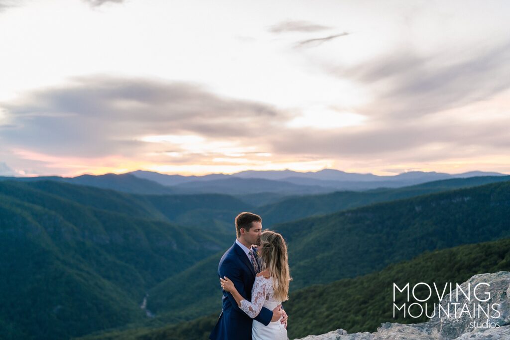 Natalie and Will Kiss on a Mountain top with the sunset behind them